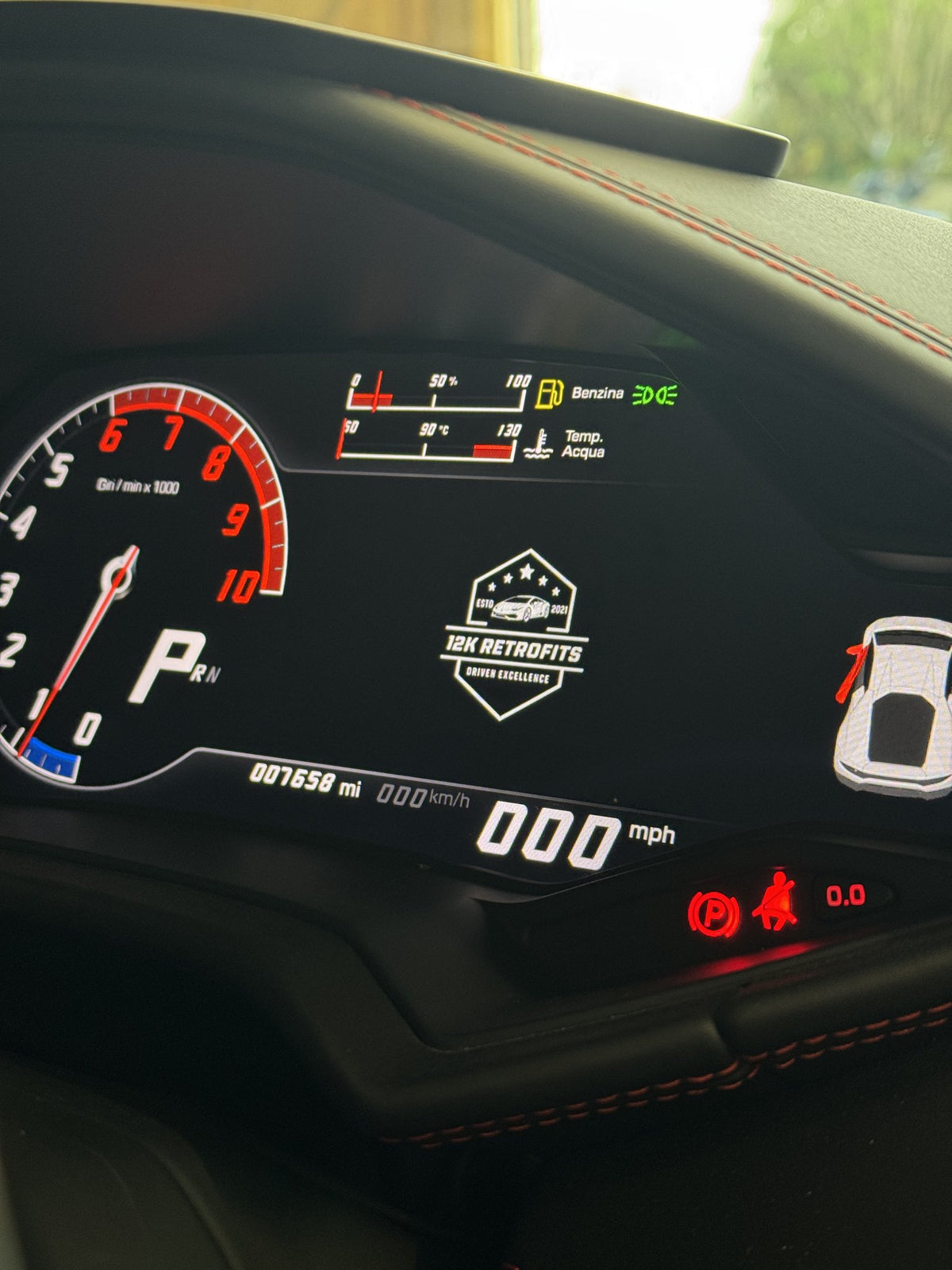 12K Retrofits logo on the digital instrument cluster of a Lamborghini Huracan